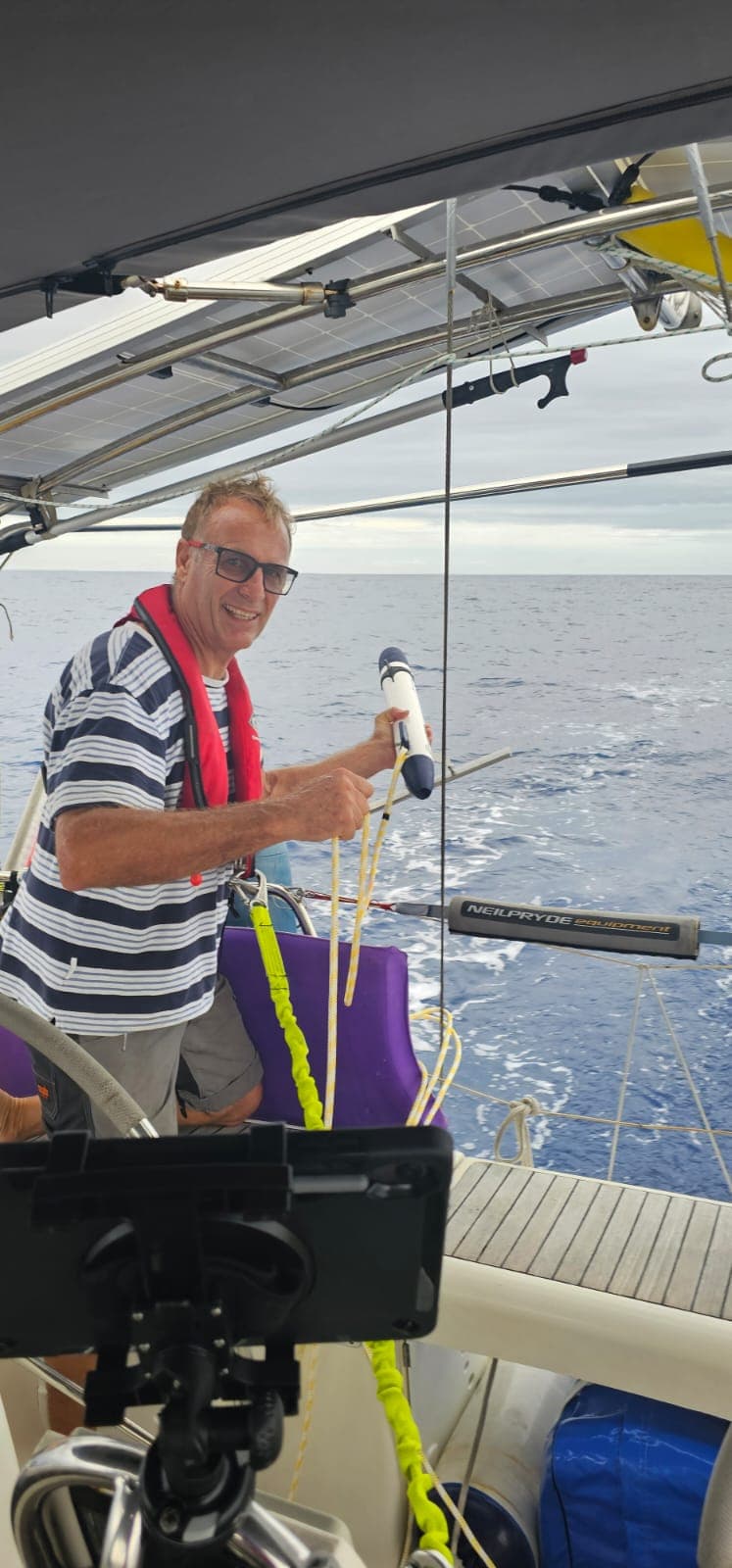 A Pacific Rally sailor holding a TorpeDNA sampler at the stern of a yacht